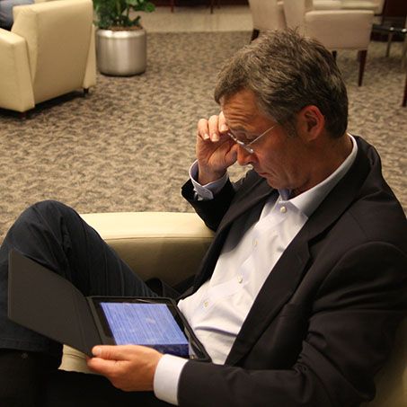 Jens Stoltenberg leser på sin Ipad. Foto.