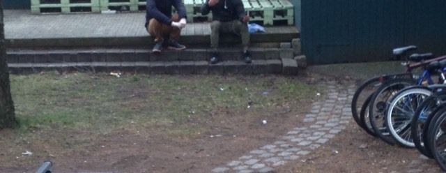 To personer i samtale, sittende i en trapp ute. Foto.