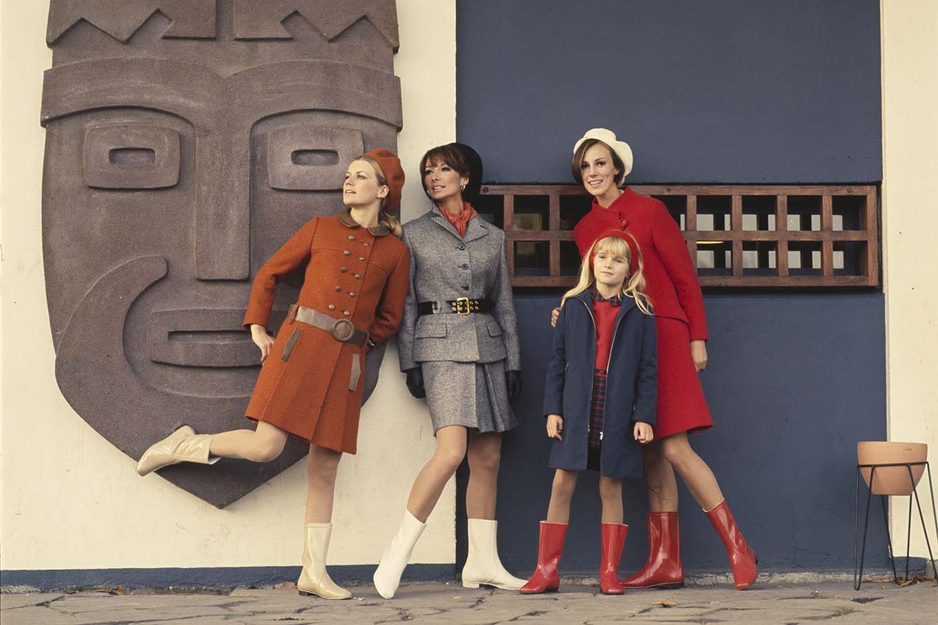 Reklame for Viking gummistøvler. Tre kvinner og en jente i drakter og røde og hvite gummistøvler ved inngangen til Kontiki-museet på Bygdøy i Oslo. Foto.