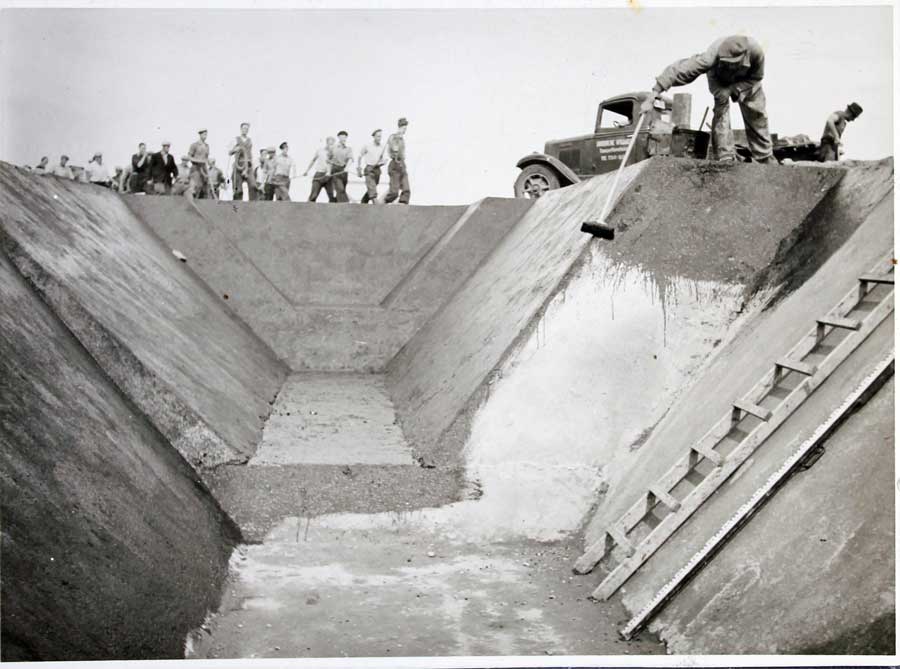 Tvangsarbeidere og en trekantformet grøft. Foto.