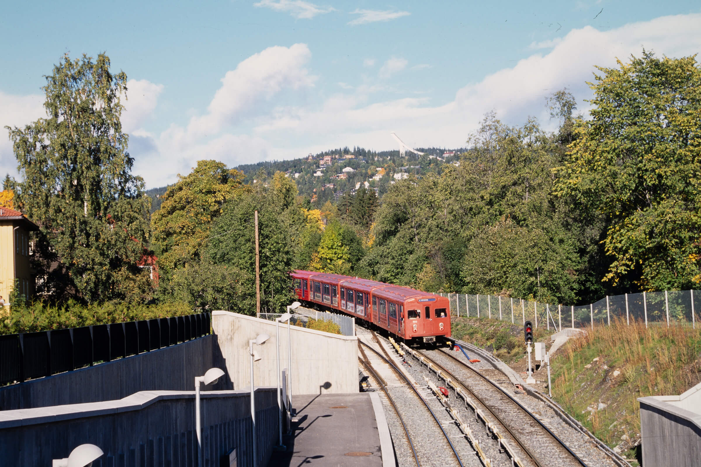 rød t-bane i grønn natur en sommer i oslo