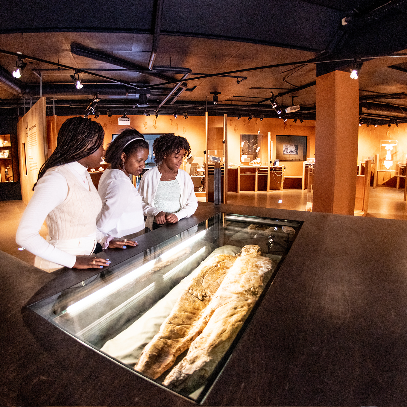 A girl in a lab coat raises her hand. Photo.  
