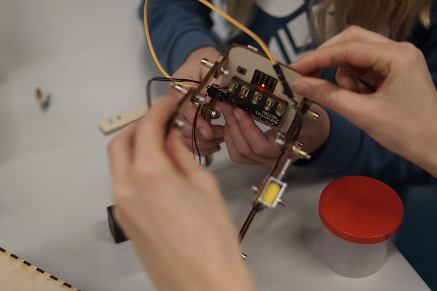 En barn i labfrakk som heller hvit pulver i enn jumbo testerør. Foto. 