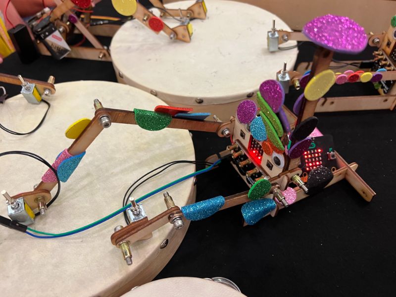 En jente i labfrakk rekker opp hånden. Foto. 