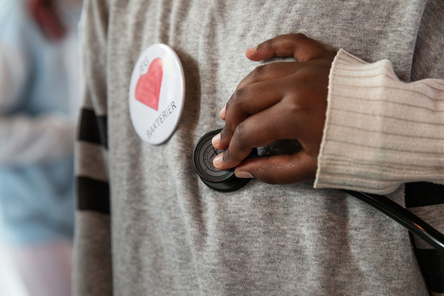 Barnehånd som holder et stetoskop mot brystet til et annet barn