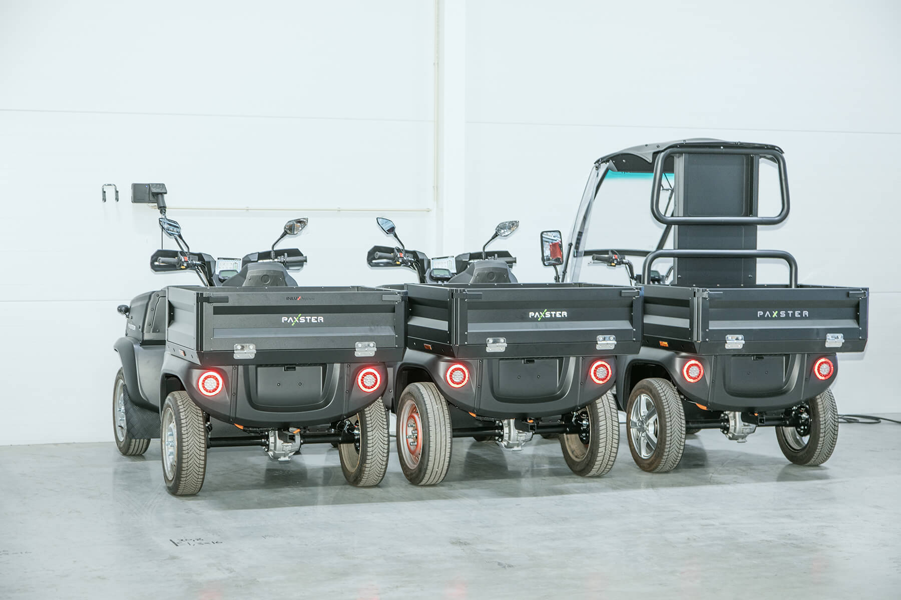To svarte Paxster Cargo og én Paxster XL parkert