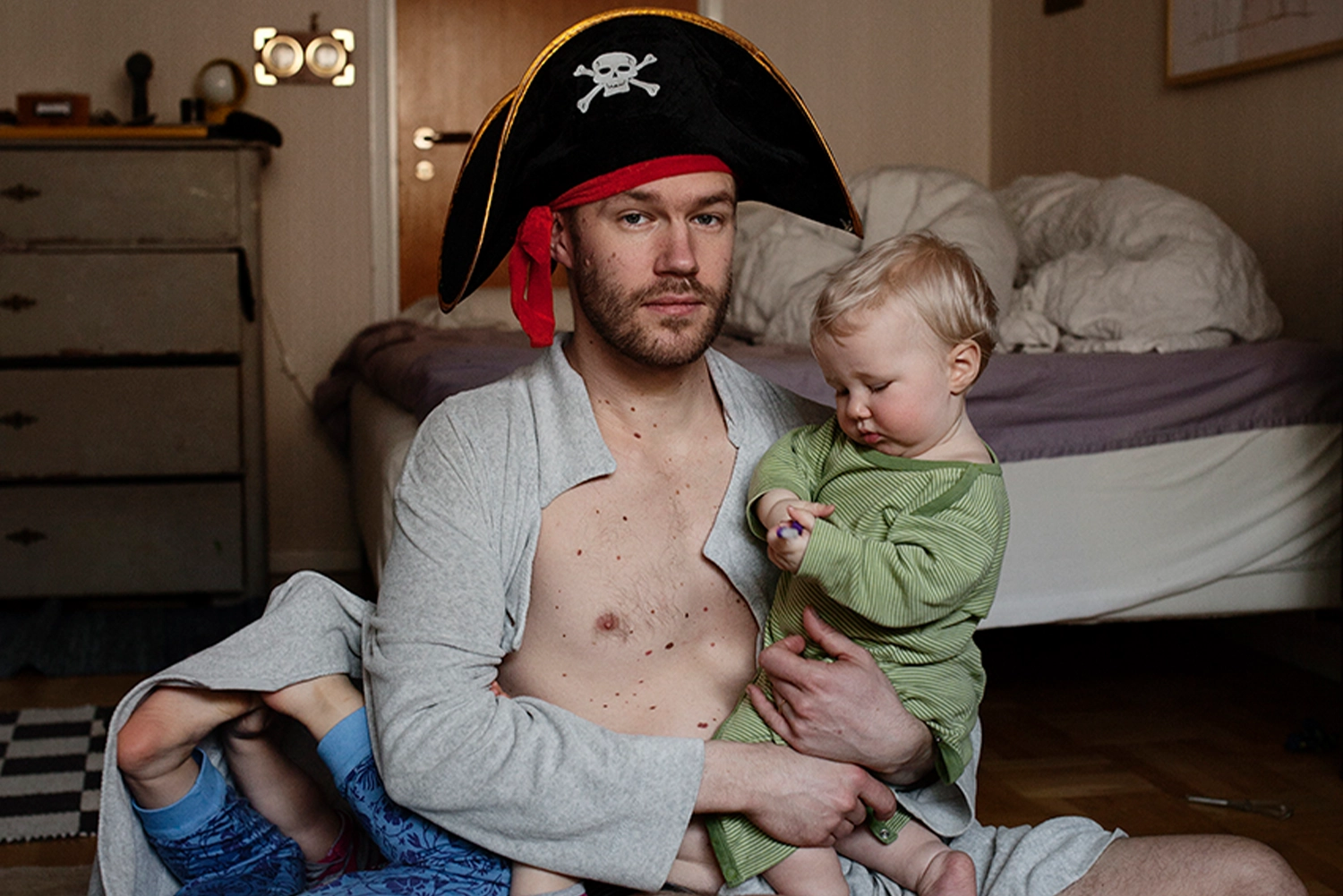 portrett av en far med pirathatt og to unger