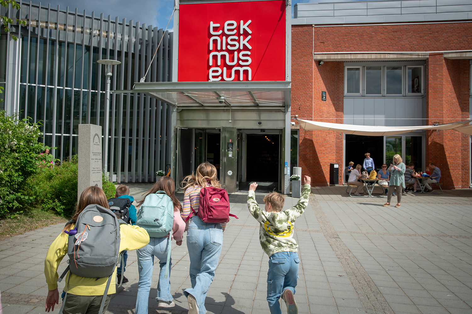 Child with backpack running towards the entrance to The Norwegian Museum of Science and Technology
