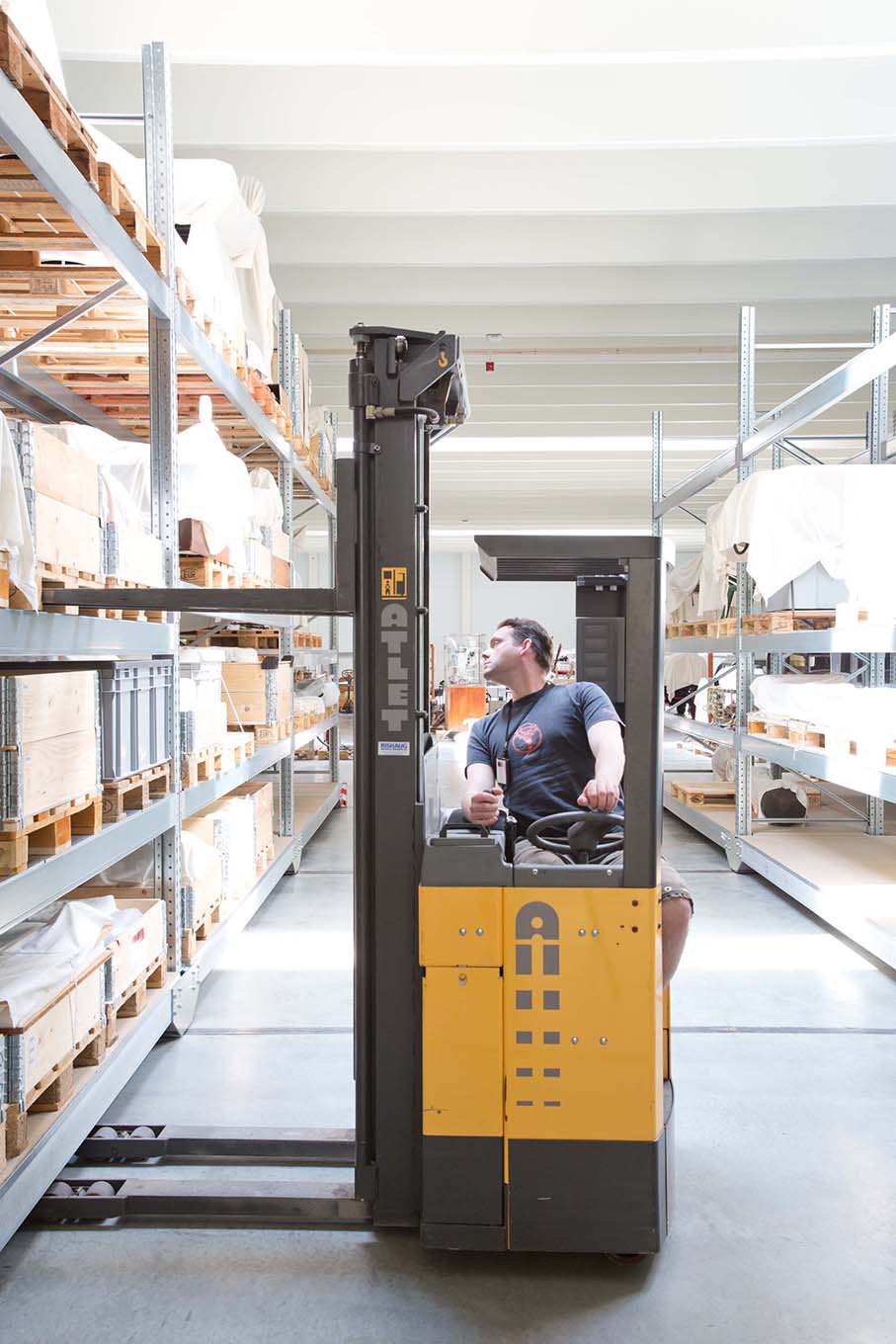 A lift is carefully maneuvered between the shelves in the museum warehouse at Gjerdrum. Photo: The Norwegian Museum of Science and Technology / Håkon Bergseth.