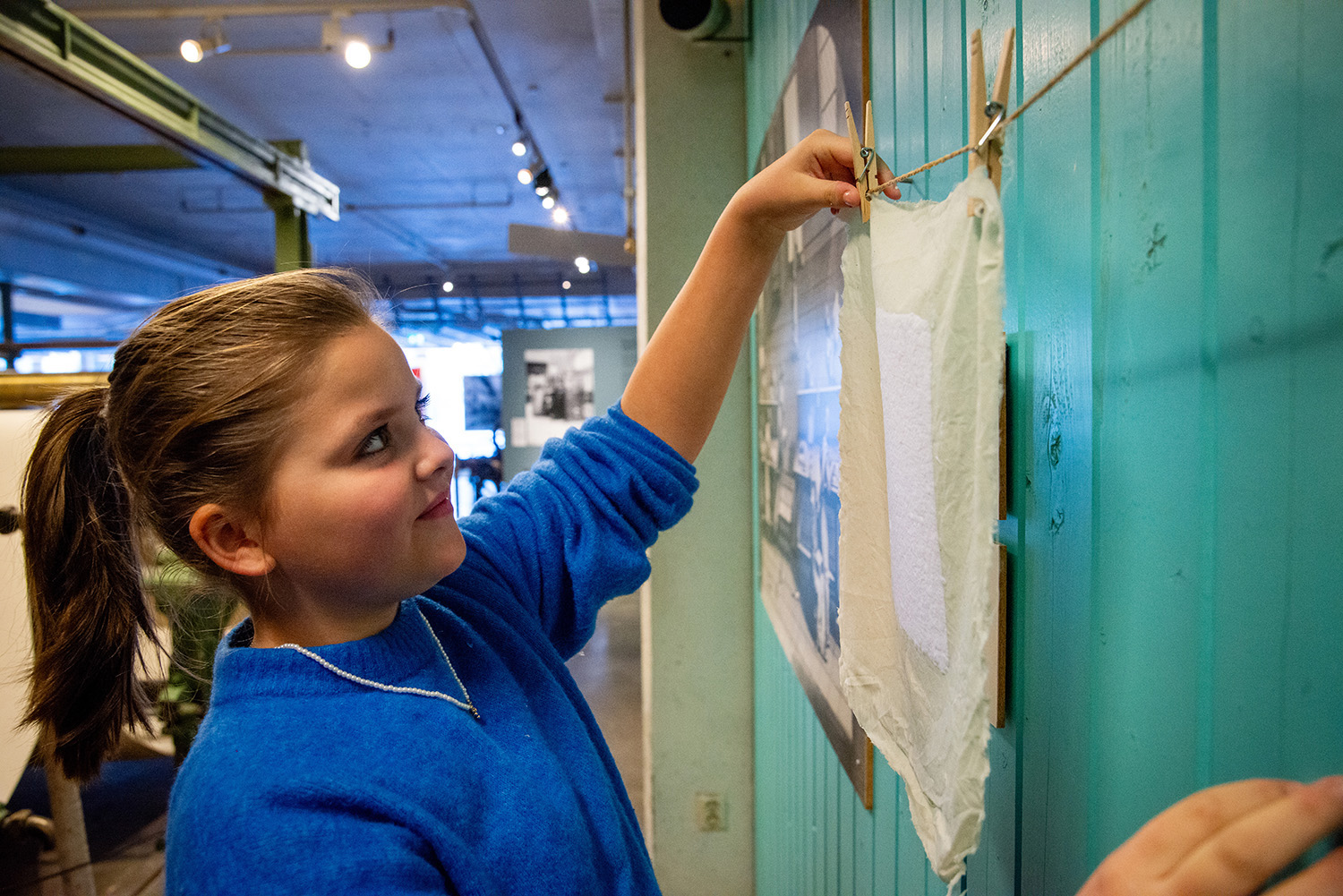Girl hanging up a handmade sheet of paper