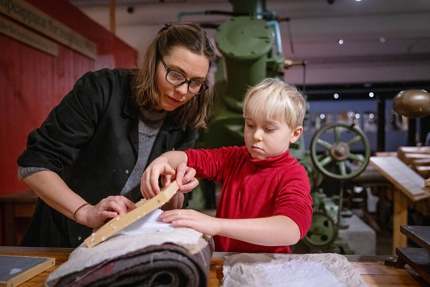 Museum educator and boy who makes paper