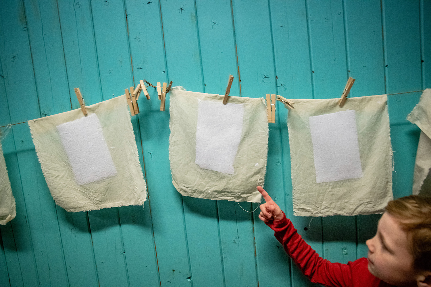 Boy pointing at paper hanging to dry