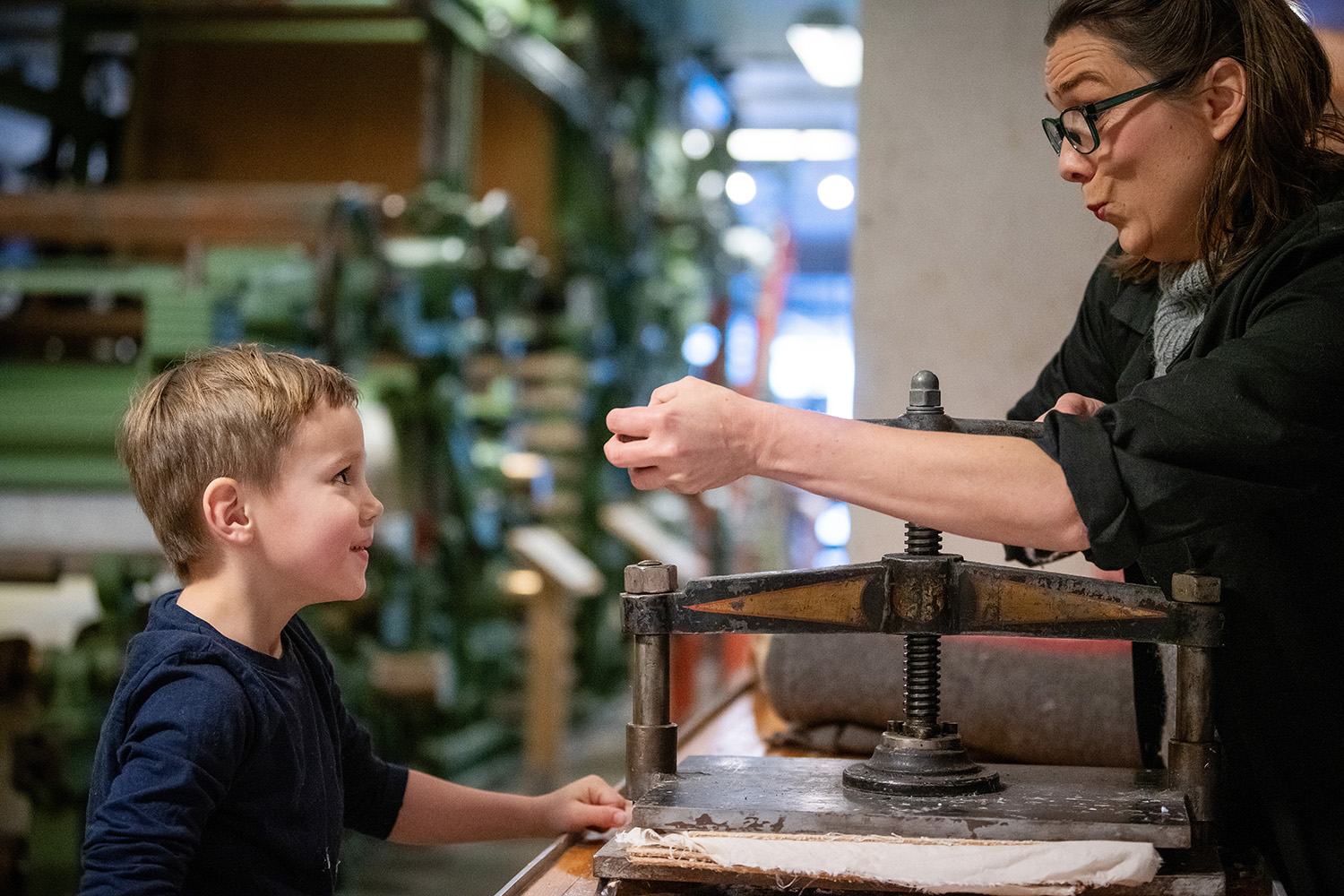 Museum educator and boy who makes paper