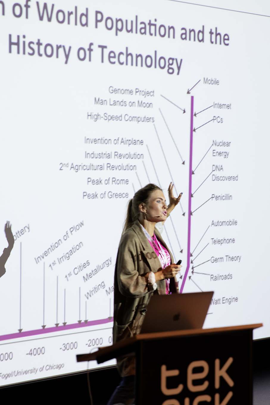 Woman giving a lecture with a slide in the background. Photo. 