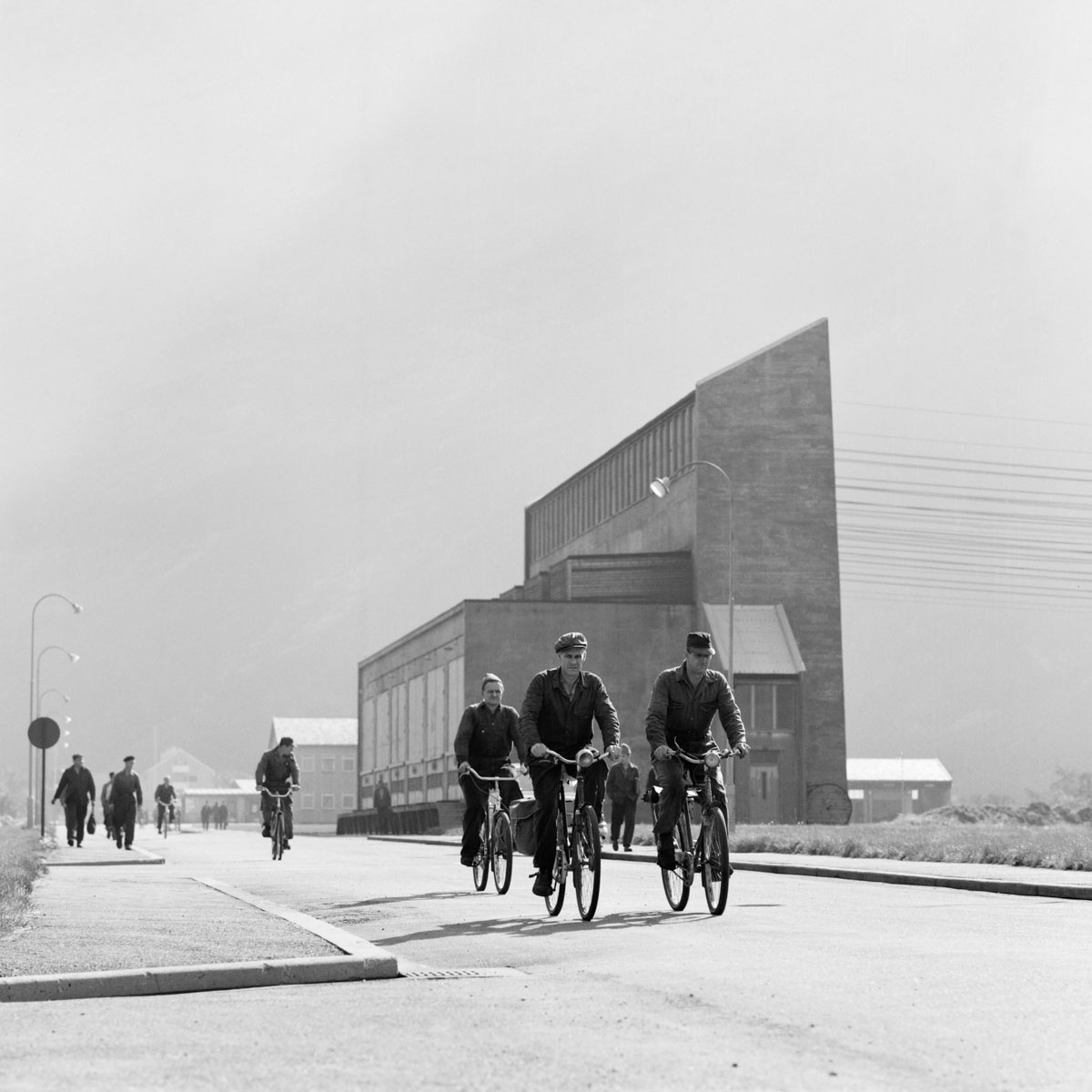 a group of workers on bicycles home from the factory