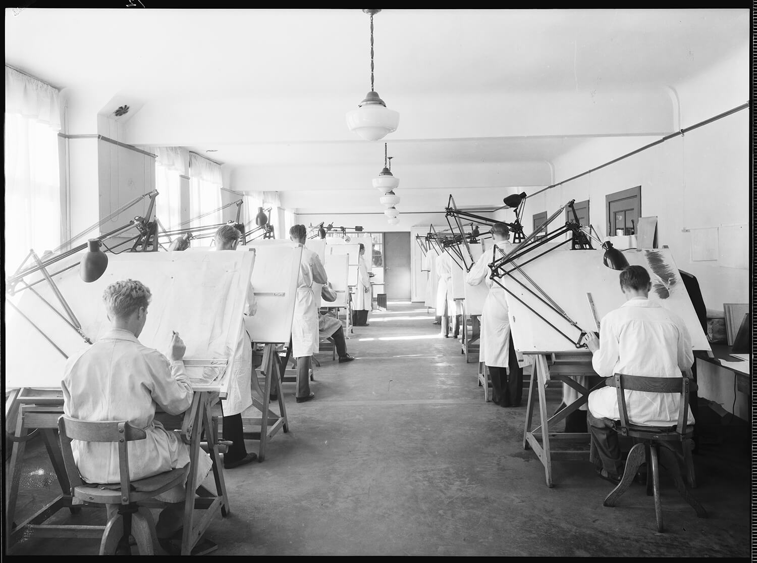 a group of people drawing on large canvases