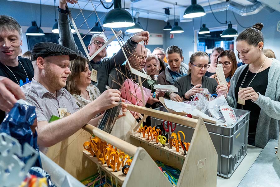 En stor gruppe voksne i aktivitet i Teknoteket. Foto.