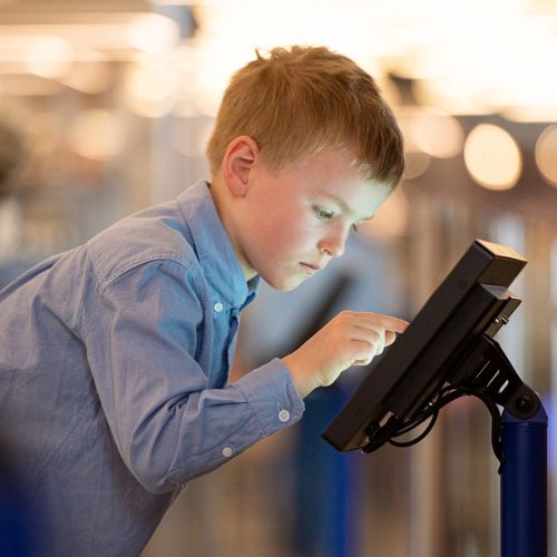Boy tapping on a screen in the IO exhibition