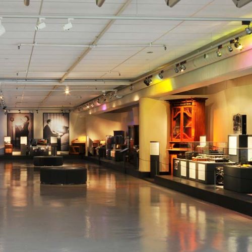 Big room with multiple old sound machines and instruments. Photo.