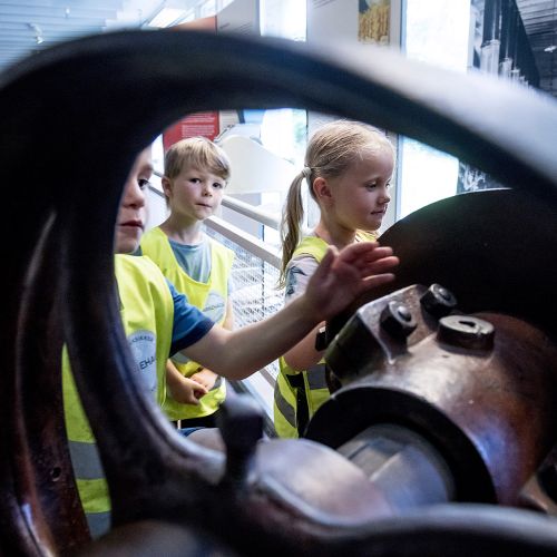 3 barn som leker med en historisk gjenstand/hjul