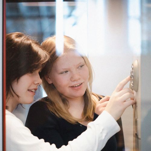 to jenter i telefonkiosk på teknisk museum ved akerselva i oslo