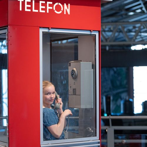 Jente i en rød telefonkiosk