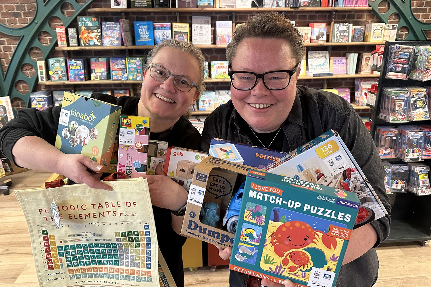 To ansatte som har armene fulle av miljøvennlige leker