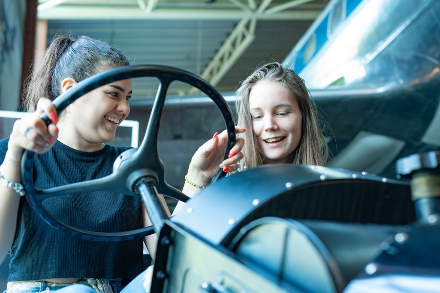 Two girls behind the wheel of a vintage car