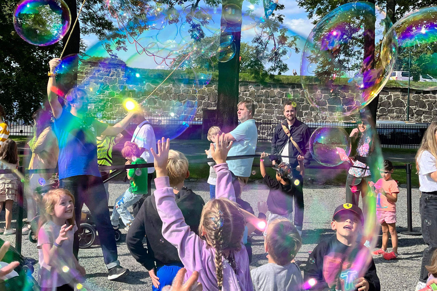 Many soap bubbles float in the air, and eager children reach for them