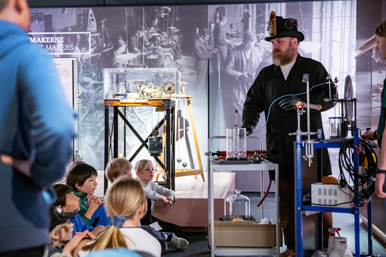 Museum pedagogue teaches children sitting on the floor