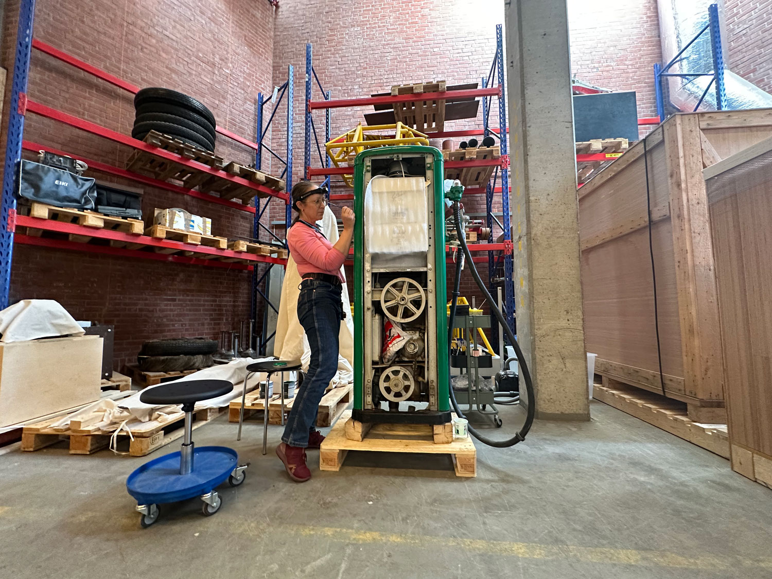 Conservator works with an old petrol pump, one of the objects of the exhibition energy in the time of climate crisis