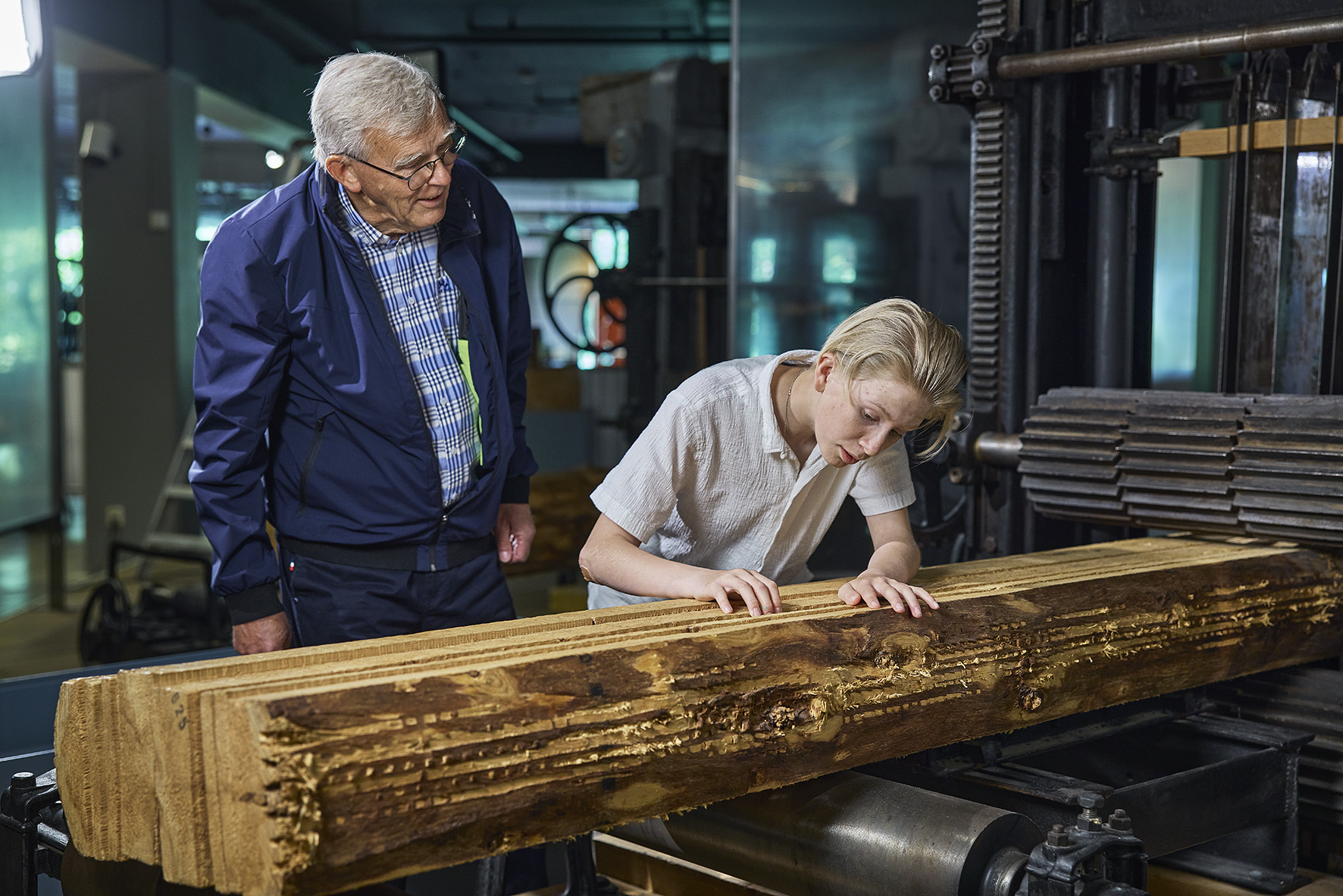 Et barn og voksne ser på gjenstander i montere