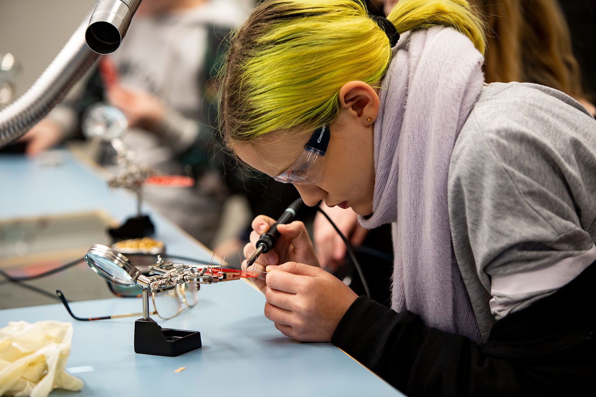 Girl and a science center teacher look at a PC in a teaching room