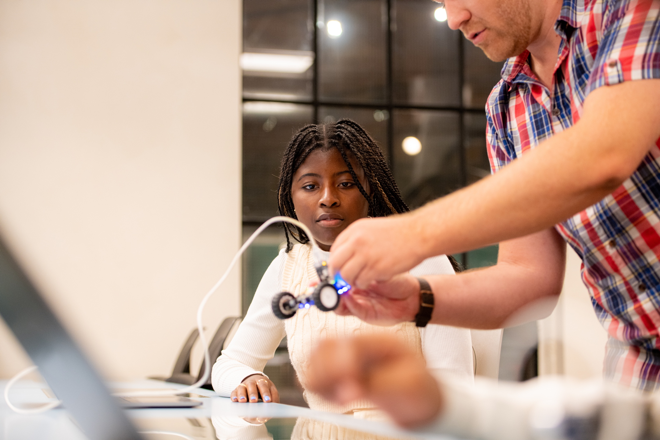 Girl and a science center teacher look at a PC in a teaching room