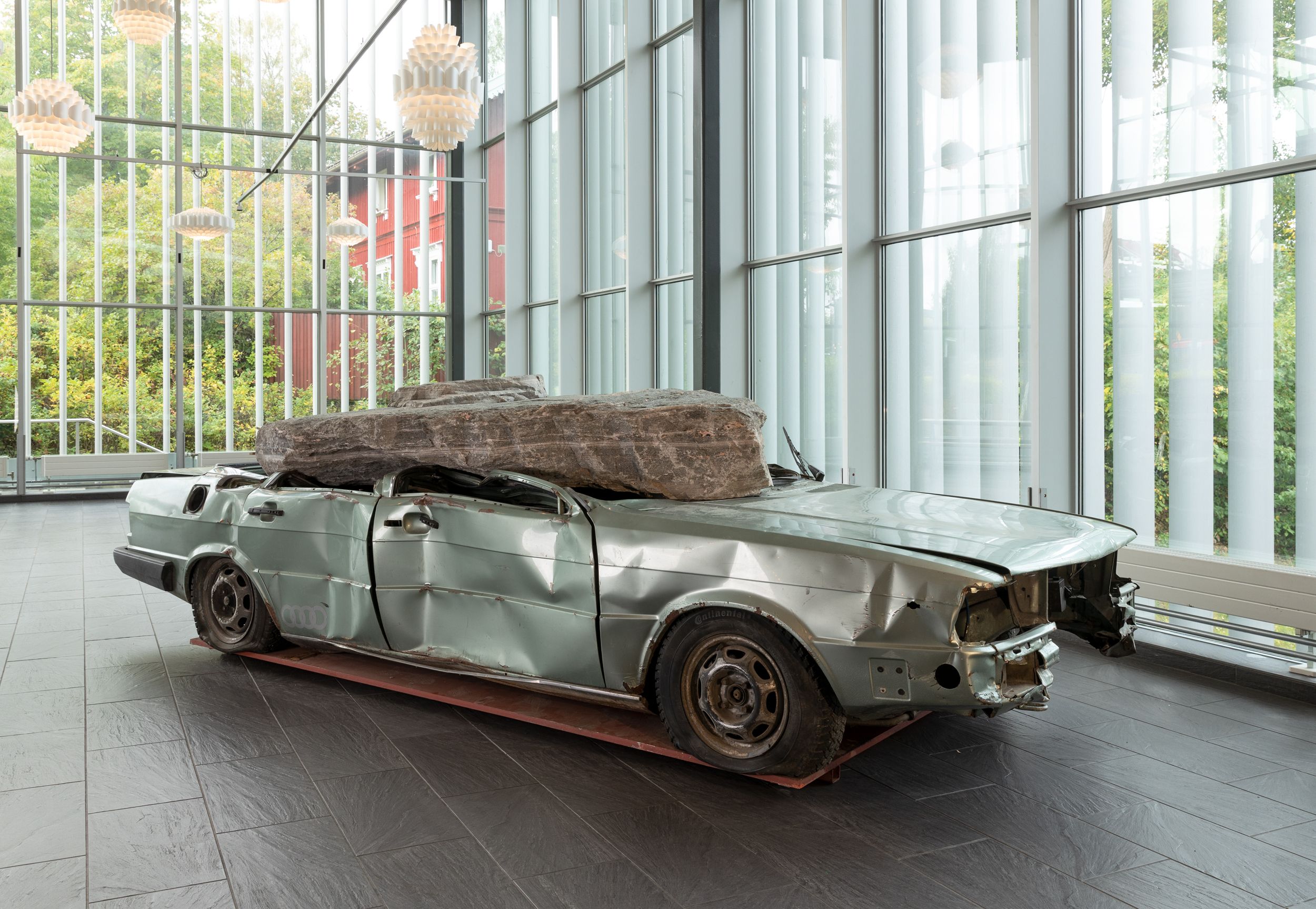 Bil som er nesten helt knust av en diger kampestein