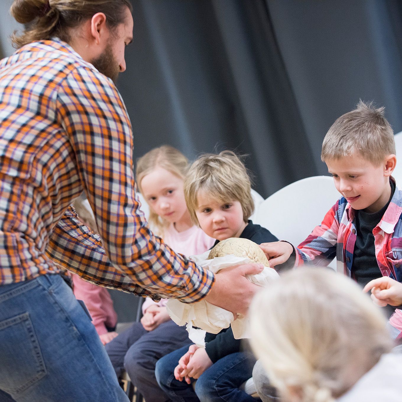 En barn i labfrakk som heller hvit pulver i enn jumbo testerør. Foto. 