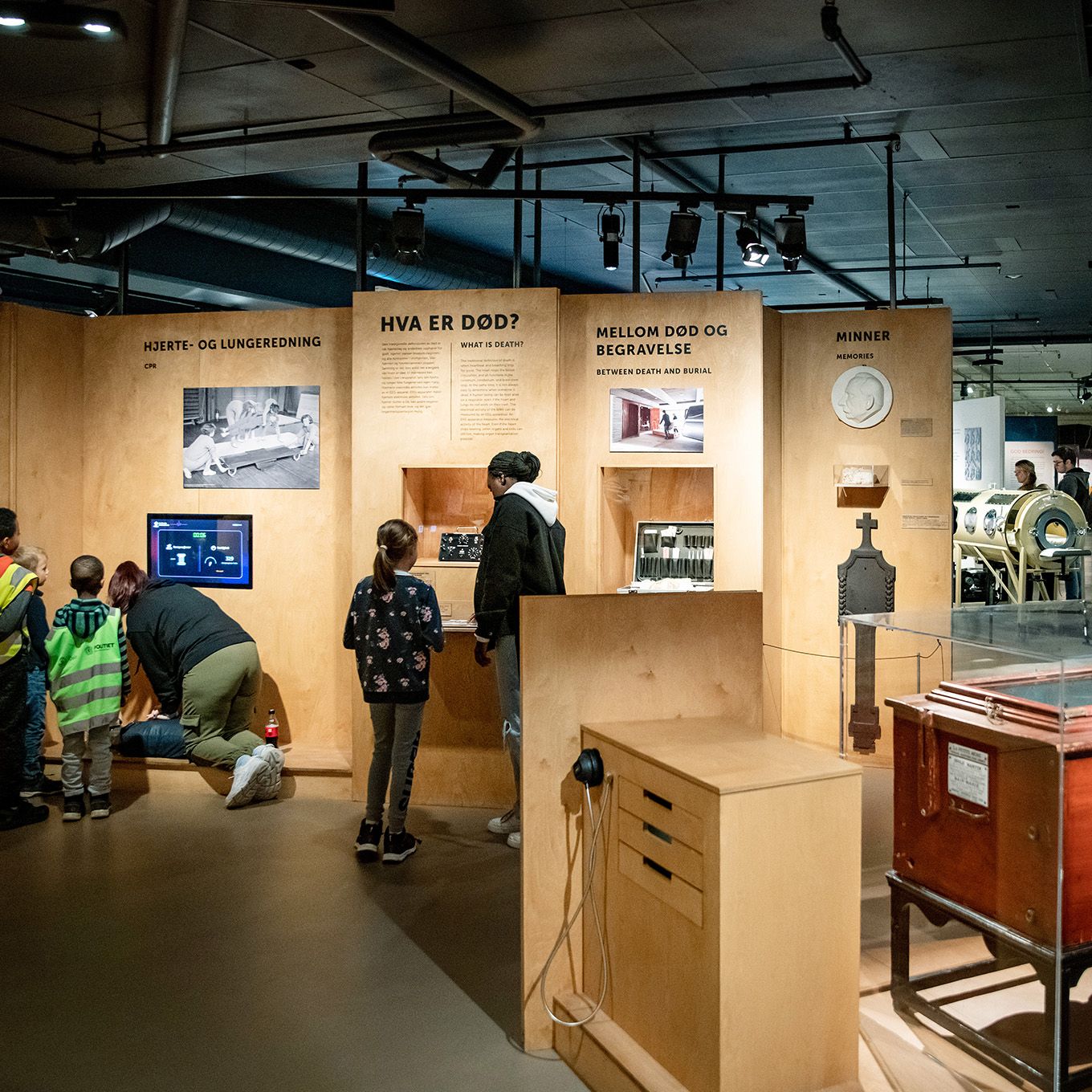 En jente i labfrakk rekker opp hånden. Foto. 