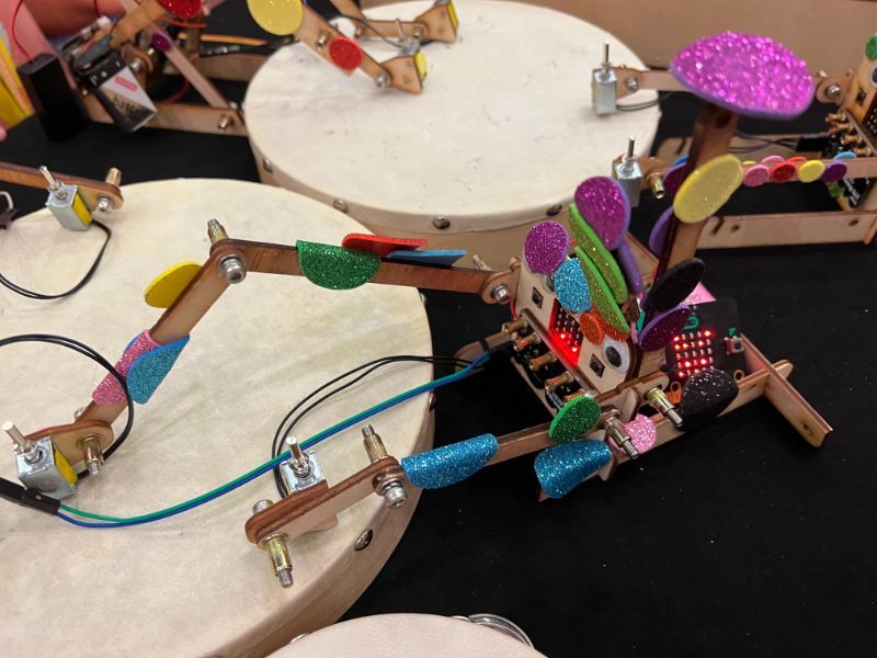 A girl in a lab coat raises her hand. Photo.  