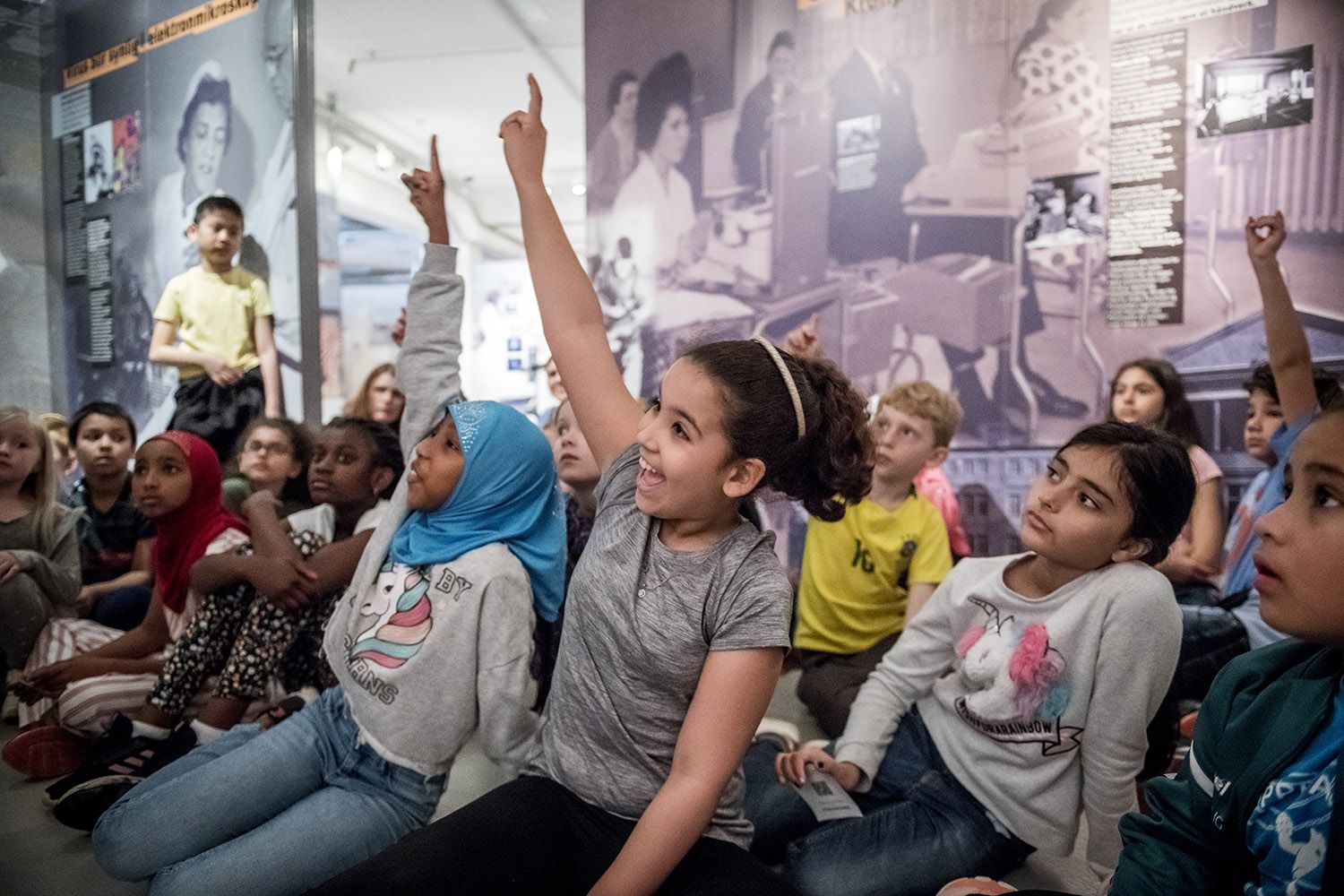 Skoleklasse med barn som rekker opp hånden
