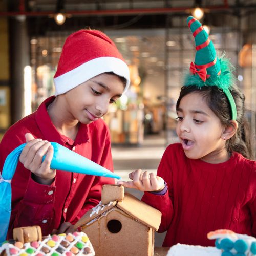barn pynter pepperkakehus på teknisk museum i oslo