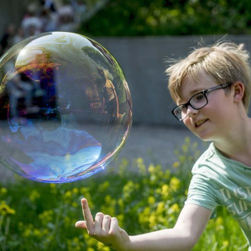 Gutt leker med såpeboble. Foto.