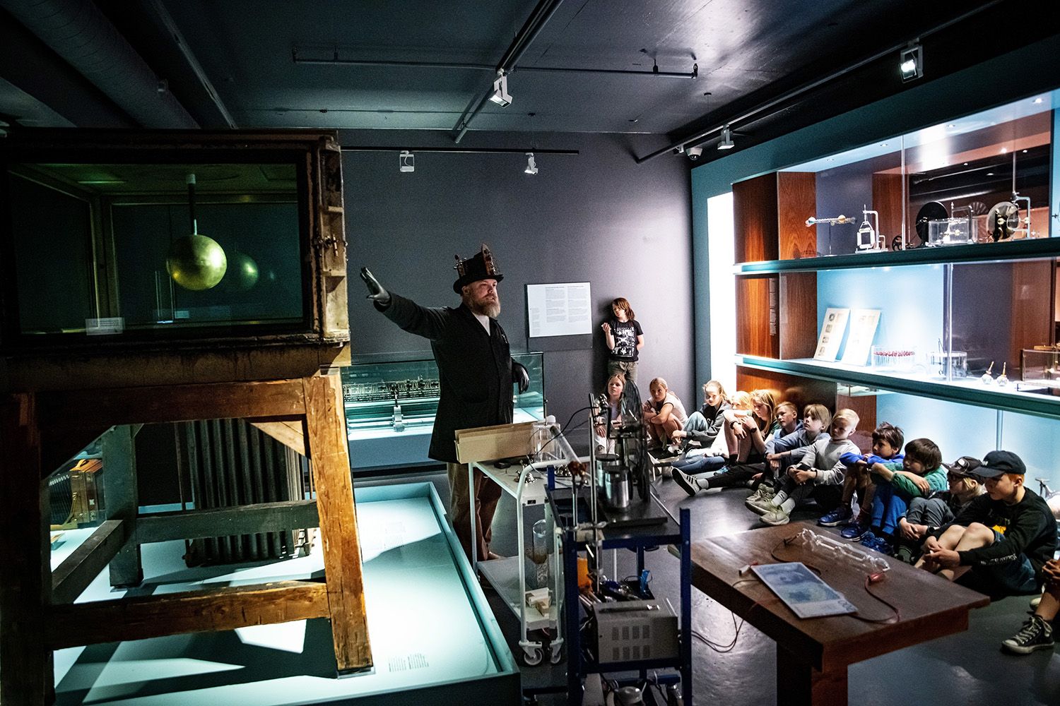 Pedagog med skoleklasse i en naturvitenskapelig utstilling