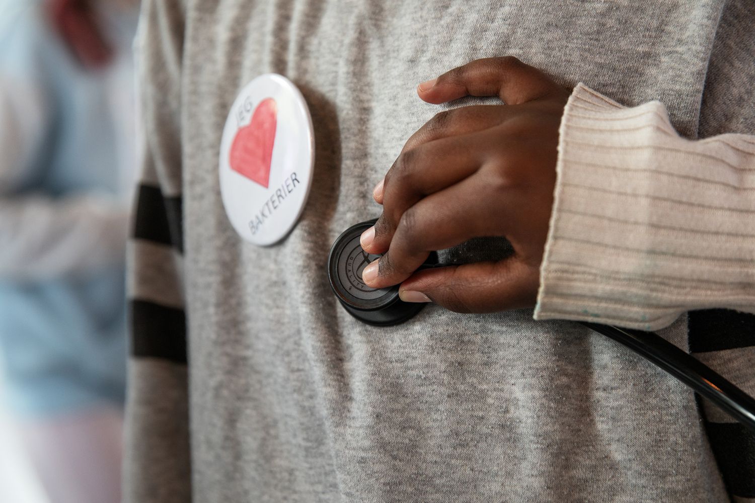 Barnehånd som holder et stetoskop mot brystet til et annet barn