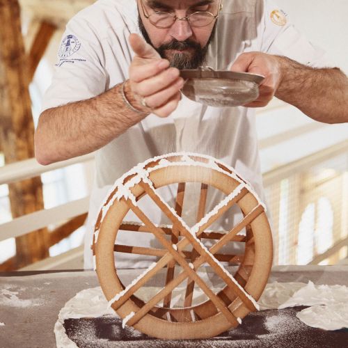 André Løvaas fra bakermesterskapet strør melis over pepperkaker hos teknisk museum